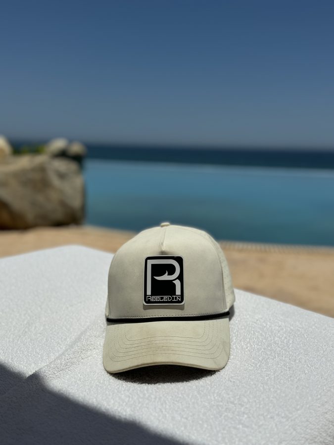 Reeled In hat on a towel by the water